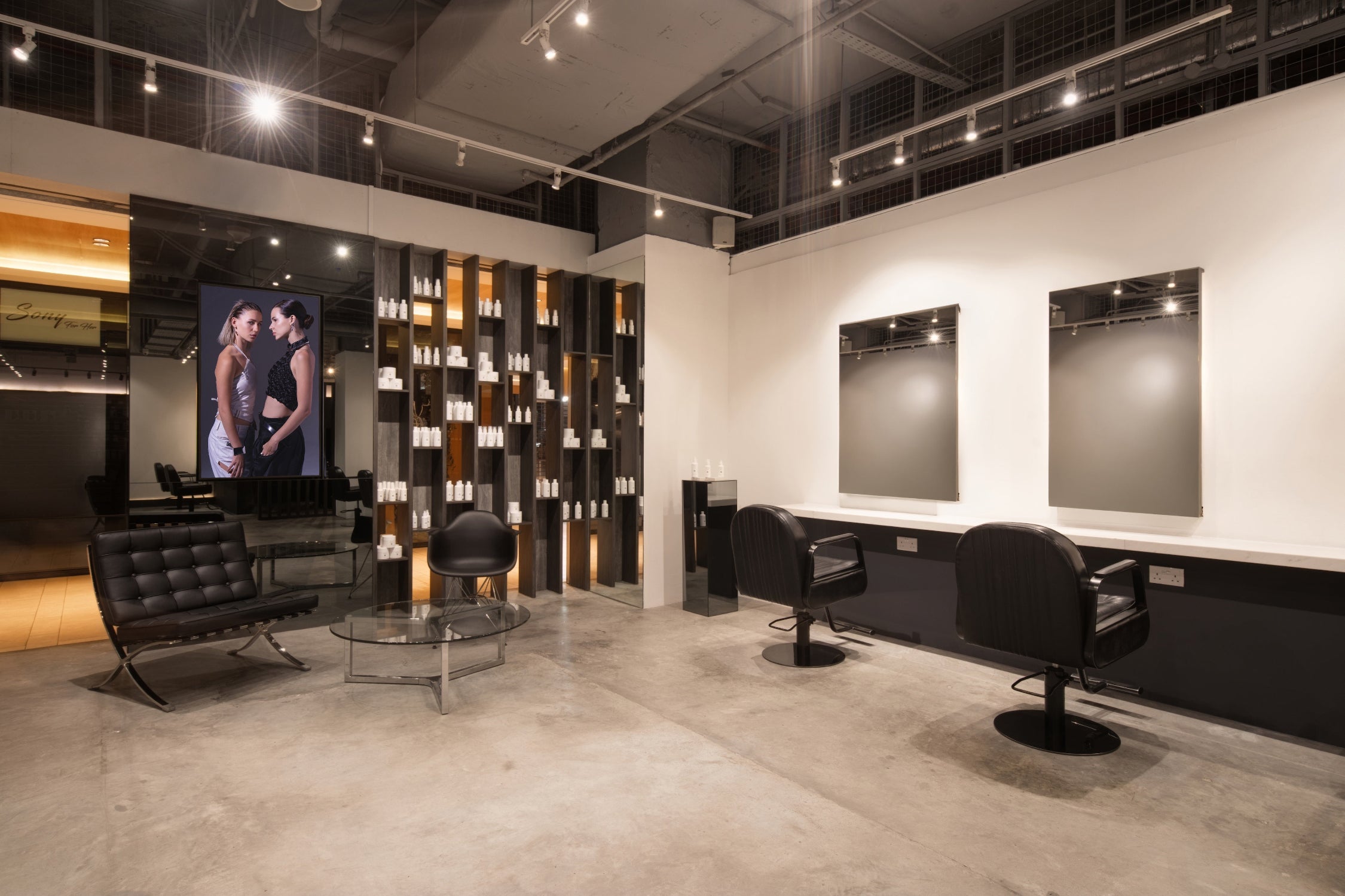 Modern waiting lounge with black leather chairs and styling stations at Yann Beyrie Paris salon
