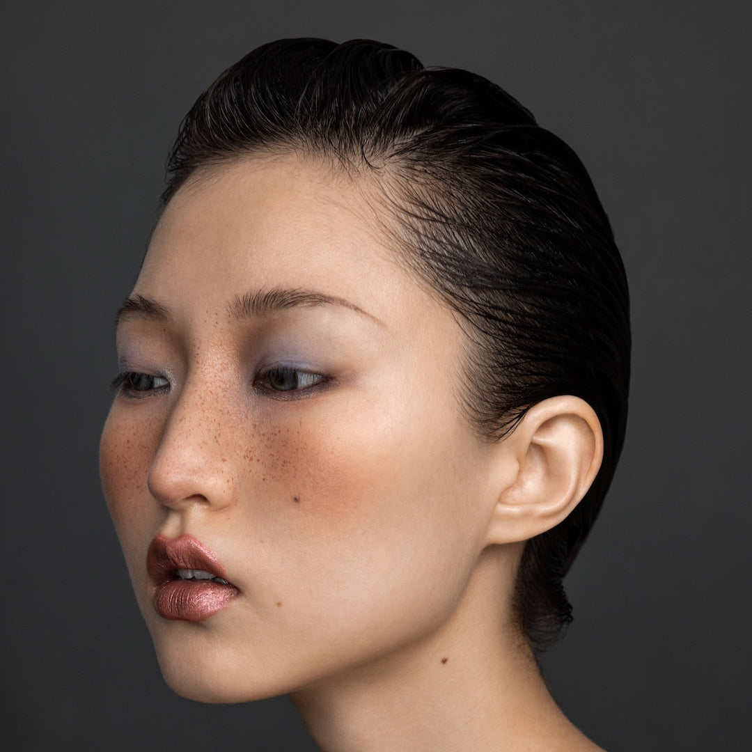 Yann Beyrie editorial slick-back hairstyle with natural freckles and metallic lipstick