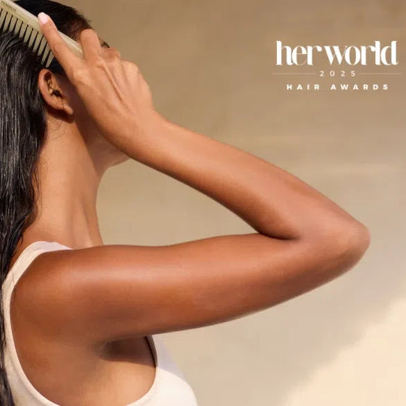 Woman combing healthy hair featured in Her World top hair salons 2025