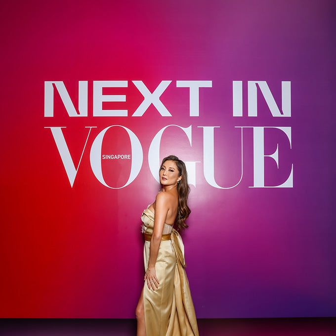 Next In Vogue 3rd anniversary gala red carpet background with model in gold dress