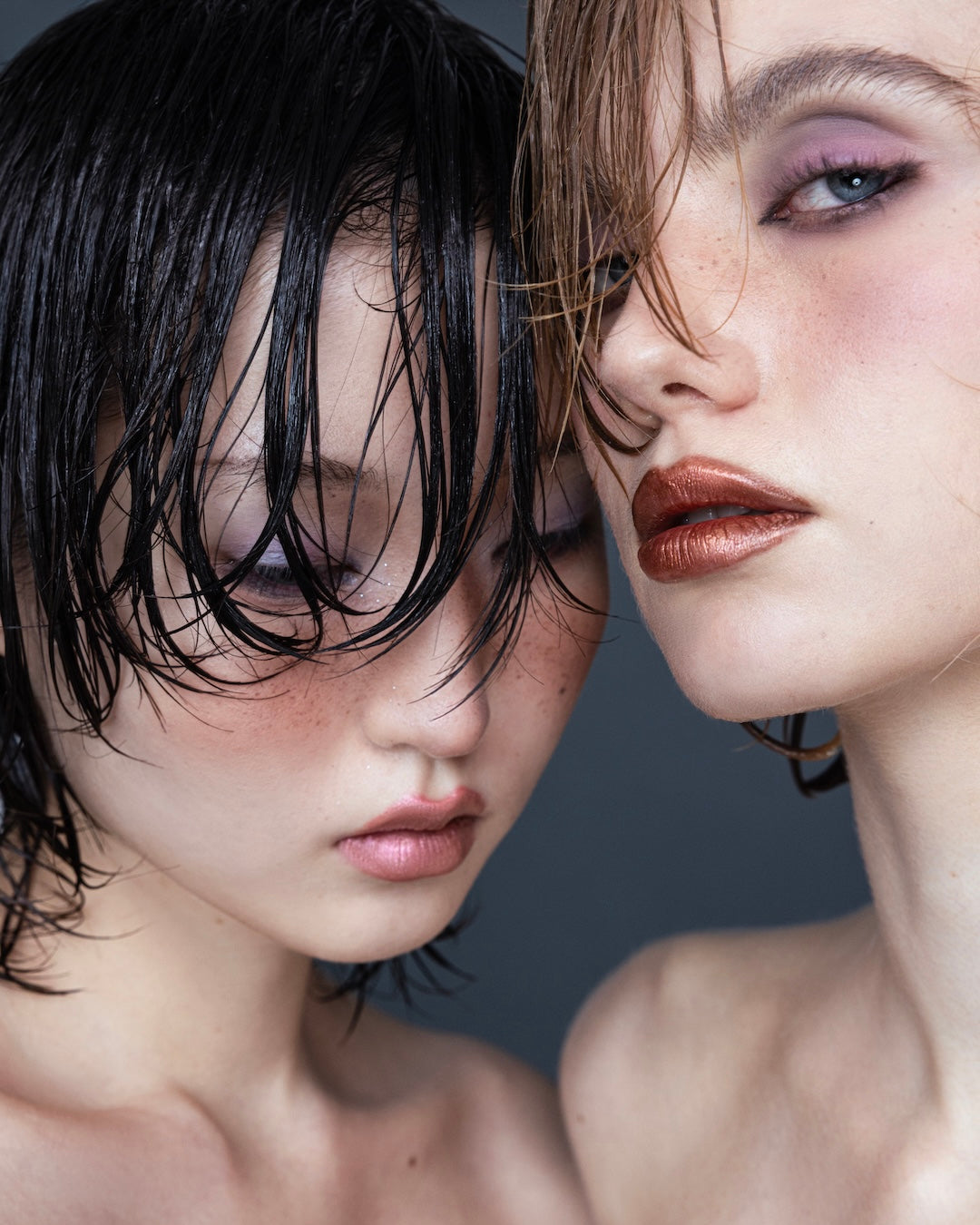 Editorial beauty shot of two female models with wet-look hair styling and metallic makeup at Yann Beyrie Paris
