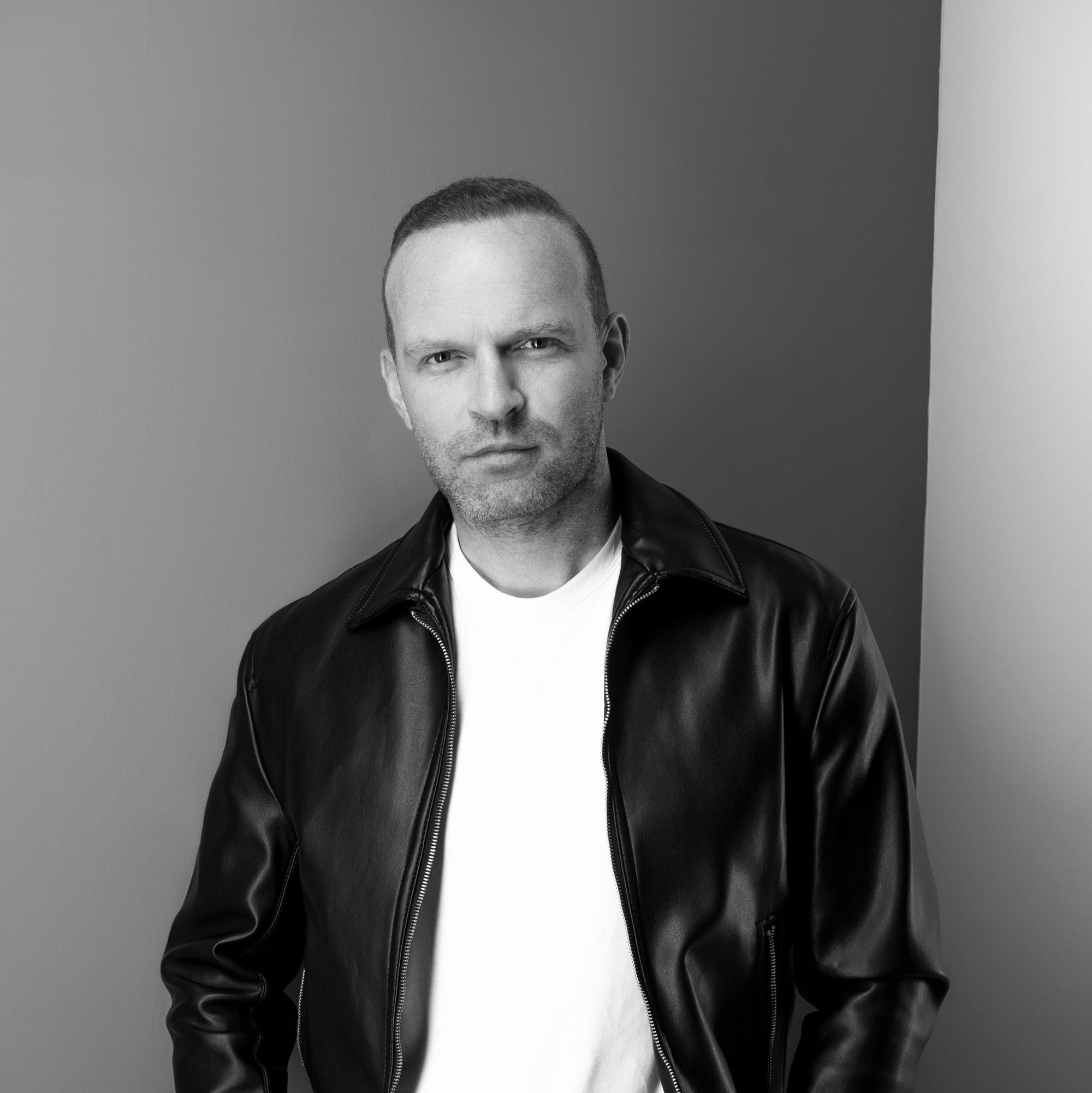 Black and white portrait of Yann Beyrie founder and director in a leather jacket