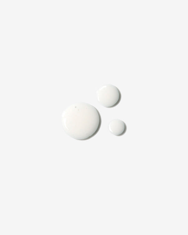 Milky white hair treatment fluid texture drops